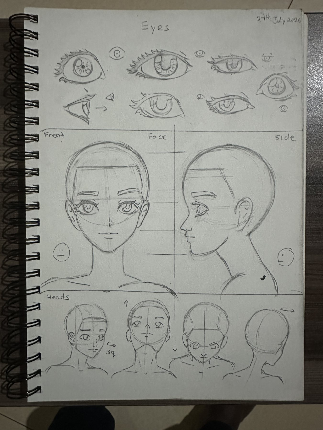 Sketchbook page studying eye construction, face divisions and head rotation in graphite.